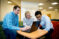 Students discuss around computer screen with Dr. Sandouka