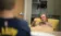 A picture of Mark Tazlaar sitting in a chair, looking at a student