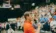 A picture of a man in an orange polo talking to a crowd
