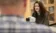 A picture of a woman sitting in front of a microscope looking at a man