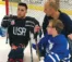 A picture of two hockey players and a coach talking