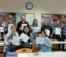 A group of students and faculty hold up their coloring pages