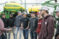 A group of students stand around a planter with a faculty member