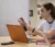 Female student uses computer and book to complete an assignment