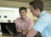 Male student with a computer interacts with another male student