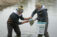 Two students in pond collecting samples