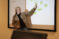 Dr. Sandouka points to the screen in a stats class as she explains a concept