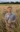 Man standing in field of grain holds onto bunch of it