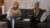A picture of two women sitting on a couch working on laptops
