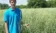 A person in a blue polo stands in the prairie