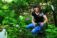 A picture of a woman holding two jars in the woods