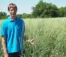 A person in a blue polo stands in the prairie