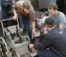 A picture of three engineers working on a wheelchair