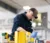 Male student greases a piece of equipment in the high bay in the Agriculture Stewardship Center