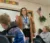 A student teacher stands at the front of class explaining a concept to her students