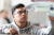 Young man with glasses looks up intently at model plane