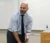 Professor Matthews stands at the front of class and smiles as he says something