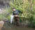A male student looks into a net as he wades in a stream