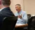 A city manager sits at a table and talks during a council meeting