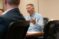A city manager sits at a table and talks during a council meeting