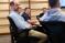 a group sits around the table in a city council meeting