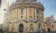 A picture of a student in front of an old building