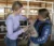 Two female students give a lamb a shot