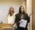 two female students present in front of the class