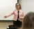A professor in a pink jacket lectures to the class