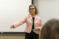 A professor in a pink jacket lectures to the class