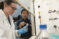 Faculty member points to test equipment used by a student in the lab