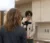 A male wearing headphones films an interview with a camera and light