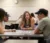 Students sit around a table with cards on it playing a Spanish/English vocabulary game