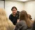 Professor Brons leans over a table of student talking about a Spanish/English activity