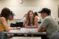 Students sit around a table with cards on it playing a Spanish/English vocabulary game