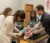 A professor helps two students as they tape another student's ankle