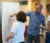A professor and two students work on a diagram on a whiteboard