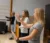 Three female students practice arm positions in conducting class