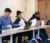 Three students sit at table and listen to class lecture