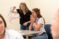 Two girls look at a creation of pipe cleaners as they do the brain game in class