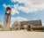 Clocktower and building under bright blue sky with puffy clouds