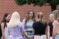 Group of young female adults stand in circle outside to pray