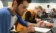 A picture of two students taking notes in a lab