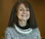 A picture of a woman in a sweater smiling