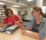 Two ladies sift through old tapes in the library