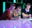 Three men lean on a counter