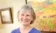 Judy Thompson smiles while holding paintbrushes