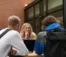 Students sit at a picnic table and study together.