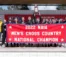 Runners stand with a banner and a national champions trophy