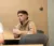 A Dordt student sitting at his desk looking at the front of the room with his laptop in front of him